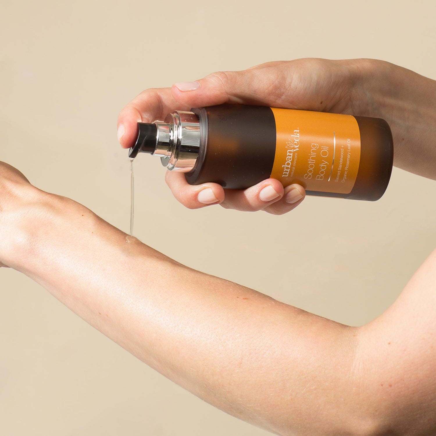 Sandalwood body oil poured onto a hand for massage - urban veda